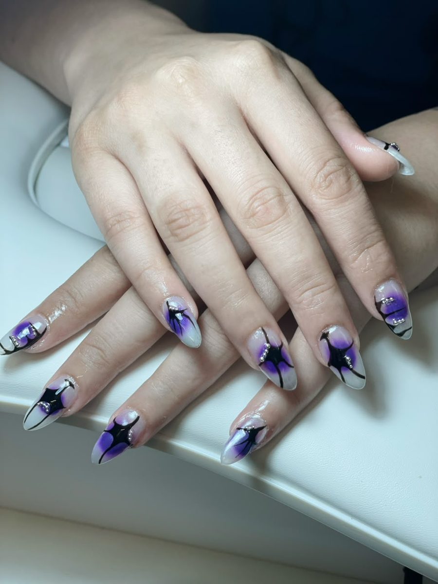 Purple and black abstract nail art on almond nails by Kim's Studio Lahore